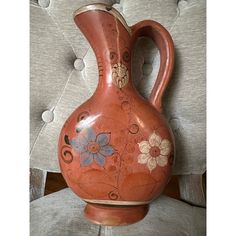 a red vase sitting on top of a chair