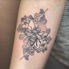 a black and white photo of a bee with flowers on it's back leg