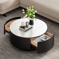 a coffee table with an open drawer underneath it and flowers in a vase on top