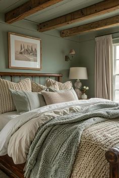 a bedroom with green walls and white linens on the bed, along with two framed pictures