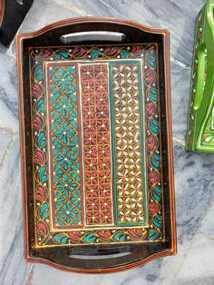 an ornately decorated tray sits on a marble countertop next to other decorative items