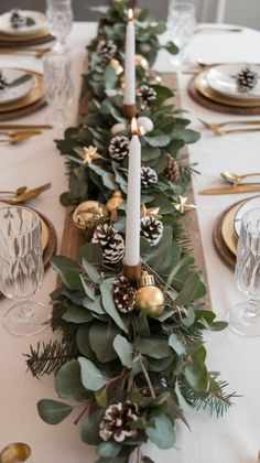 the table is set with pine cones, greenery and candles for an elegant look