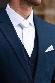 a man wearing a blue suit and white shirt