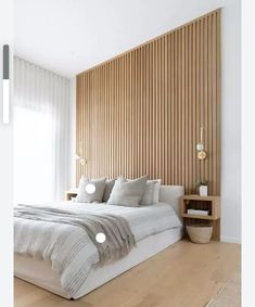 a large bed sitting in the middle of a bedroom next to a wooden headboard