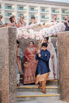 a man and woman are walking down the stairs