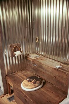 a pizza sitting on top of a wooden table next to a metal wall in a room