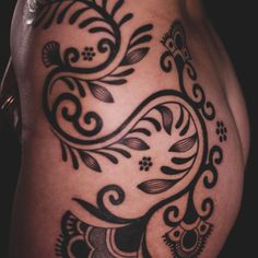 a black and white tattoo design on the side of a woman's stomach