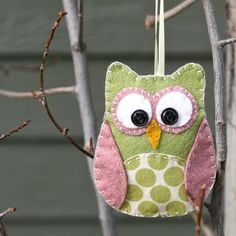 an owl ornament hanging from a tree branch