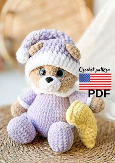 a crocheted teddy bear sitting on top of a table next to an american flag