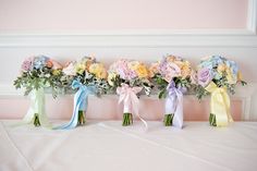 four bouquets of flowers are lined up on the table