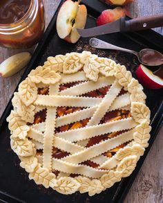 an apple pie on a baking tray next to sliced apples