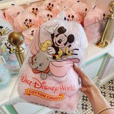 someone is holding up a plastic bag with mickey mouse and other merchandise in the background