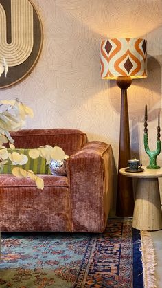 a living room filled with furniture next to a lamp and rug on top of a wooden table