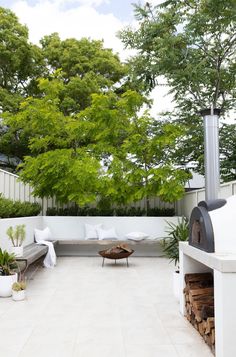 an outdoor living area with white furniture and trees