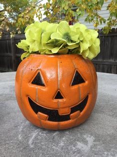 a pumpkin shaped planter with flowers in it