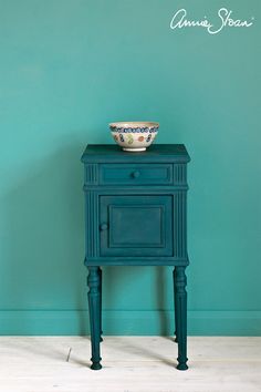 a blue cabinet with a bowl on top