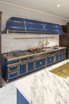 a kitchen with marble counter tops and blue oven hoods on the wall above it