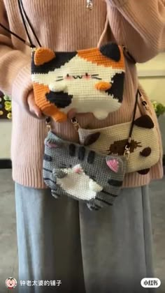 a woman is holding two small purses with cats on the front and one cat on the back