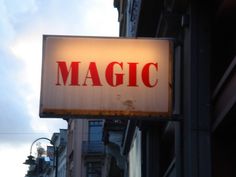 a close up of a sign on the side of a building with buildings in the background