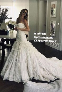 a woman in a white wedding dress is taking a selfie with her cell phone