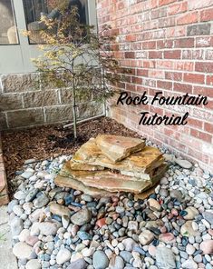 rocks are stacked on top of each other in front of a brick building with the words rock fountain