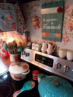 a stove top oven sitting inside of a kitchen next to a wall covered in flowers