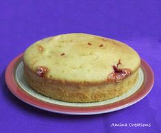 a cake sitting on top of a white and red plate next to a purple background