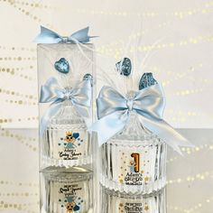 two clear bottles with blue bows on them