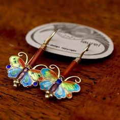 A stylized butterfly flies below a red faience bead in this gold vermeil drop earring. This is a great example of a signature Laurel style - and one of the first butterflies in the Laurel inc line to showcase Laurel's signature style. The twisted antenna, flowing wing shape, and vibrant color palette used on these critters was retained throughout her life. Gold over sterling silver with bright cloisonné enamel work. Measures about 1.25 inches (2 fingers) tall.Vintage stock from the 1970's - they Red Butterfly Earrings For Gift, Stylized Butterfly, 2 Fingers, Orange Jewelry, Gold Vermeil Jewelry, Insect Jewelry, Red Butterfly, Purple Jewelry, Spring Jewelry