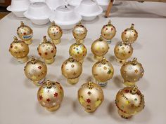 a bunch of christmas ornaments sitting on top of a white table next to each other