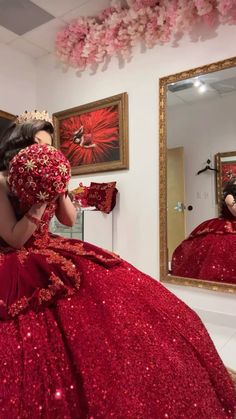 a woman in a red dress looking at herself in the mirror