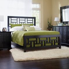 a bedroom scene complete with a bed, dresser and mirror on the sideboard in black