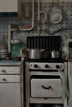 an old fashioned stove with pots and pans on it's burners in a kitchen