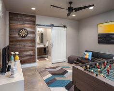 a living room filled with furniture and a dart board on the wall in front of it