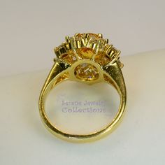 Thank you for coming in! This Vintage Ring has a strong striking yellow sapphire as its center piece. The sapphire is bezel set into a fancy setting with 8 heart and 8 round diamonds totaling 1.8 carats! Ring Size: 7.75 Total Weight: 9.58 grams Precious Metal: 18k solid gold Precious stones: -Yellow Sapphire: 2.92 carats, 9mm x 7.3mm -White Round Diamonds: 1.8 ct Hallmark: A18K Yellow Sapphire Ring With Center Stone In Yellow Gold, Luxury Gold Sapphire Ring With Accent Stones, Round Yellow Sapphire Ring With Accent Stones, Fine Jewelry Yellow Sapphire Round Ring, Yellow Sapphire Ring With Center Stone, Yellow Sapphire Rings With Halo Setting For Anniversary, Anniversary Yellow Sapphire Ring With Halo Setting, Gold Topaz Ring With Halo Setting, Oval Yellow Sapphire Ring With Center Stone