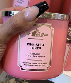 a hand holding a pink apple punch candle