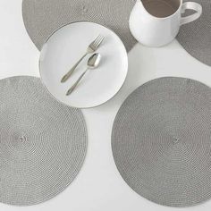 four placemats and a coffee cup on a white table