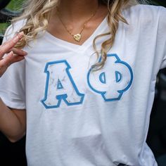 a woman wearing a t - shirt with the letter a on it