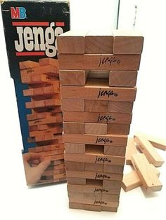 a stack of wooden blocks sitting on top of a table next to a game box