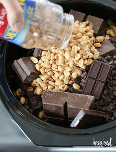 someone is pouring chocolate and peanuts into a slow cooker to make peanut butter fudges