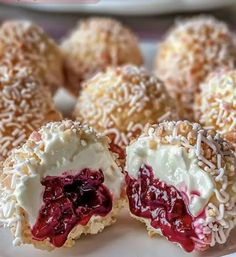 there are several desserts on the plate with white frosting and cranberry filling