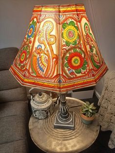 a lamp that is sitting on top of a table with a potted plant next to it