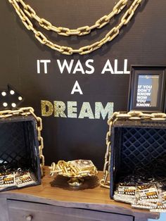 two black and gold purses sitting on top of a wooden table next to a sign that says it was all a dream