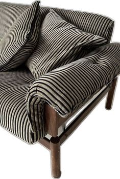 a black and white striped chair with two pillows on it's armrests