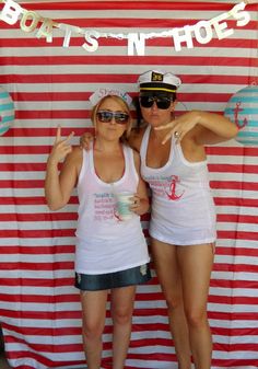 two women standing next to each other in front of a red and white striped wall