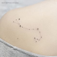 the back of a woman's shoulder with small stars on her left side and an arrow in the middle