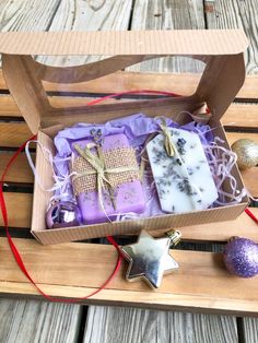 three soaps in a wooden box with christmas decorations on the table next to it