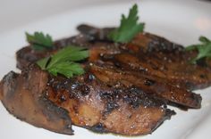 grilled meat on a plate with parsley garnish