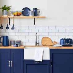 a kitchen with blue cabinets and white subway tiles on the backsplash is shown