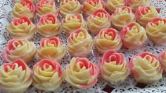 there are many small cupcakes with pink flowers on the top and yellow petals on the bottom